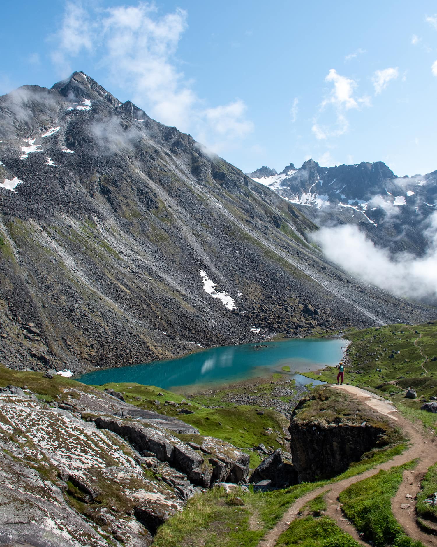 girl standing above a lake with mountain above it