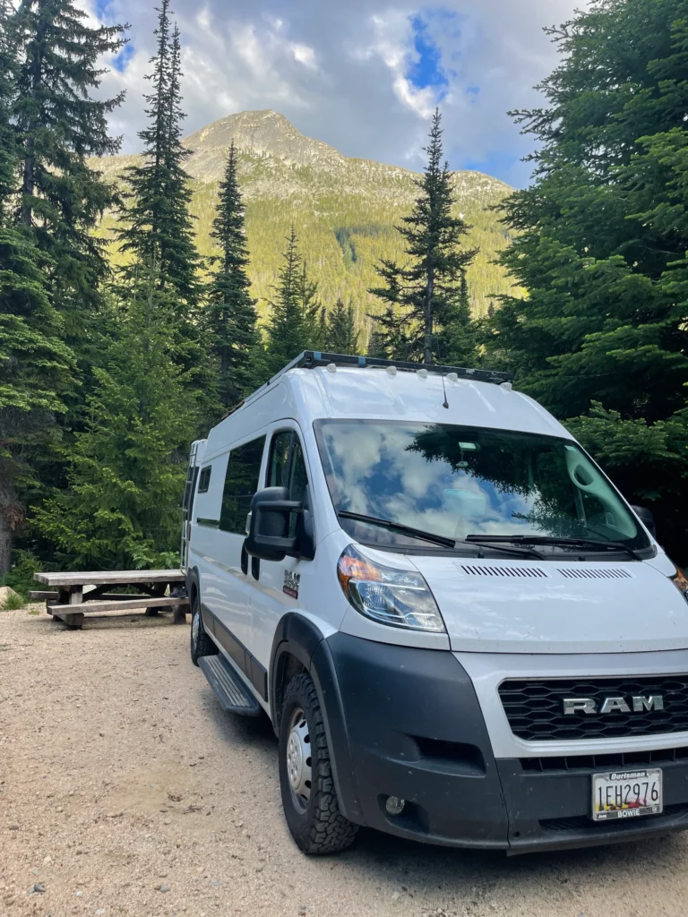 a van with moutnain behind it and a picnic bench